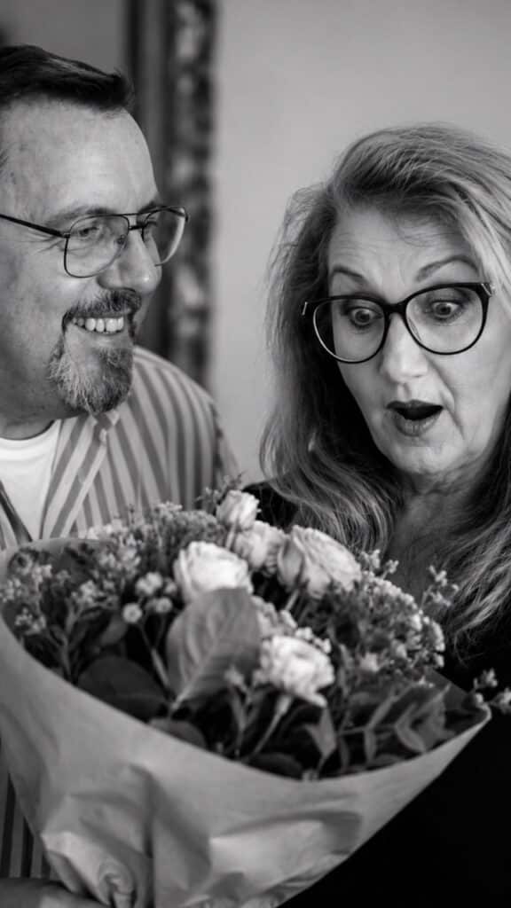 Die Frau erhält einen Blumenstrauß, überrascht schauend– emotionale Untreue in der Beziehung erkennen